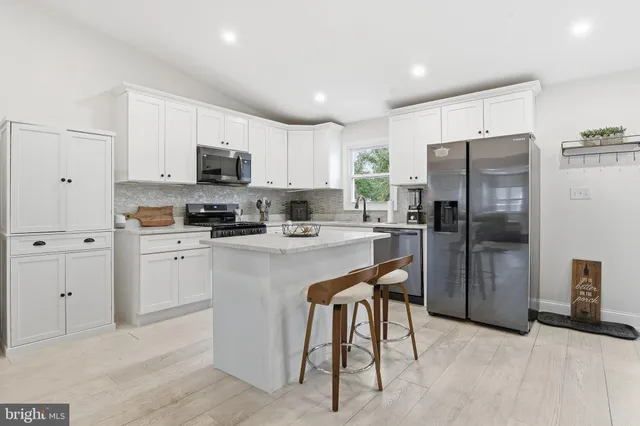 a kitchen with stainless steel appliances granite countertop a refrigerator a stove a sink a stove and a oven