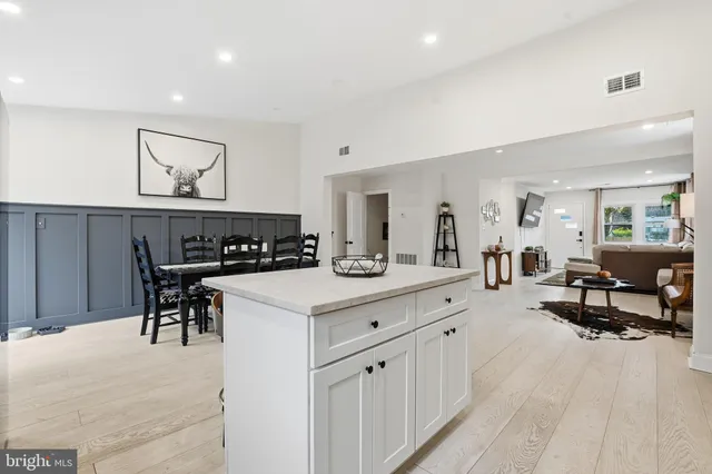 a living room with furniture and a dining table with wooden floor