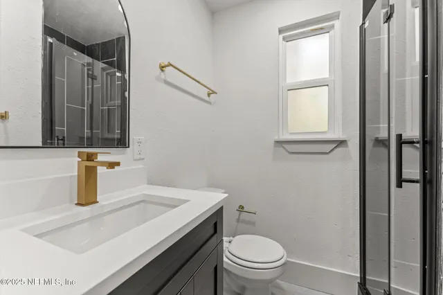 a bathroom with a sink a toilet and a window