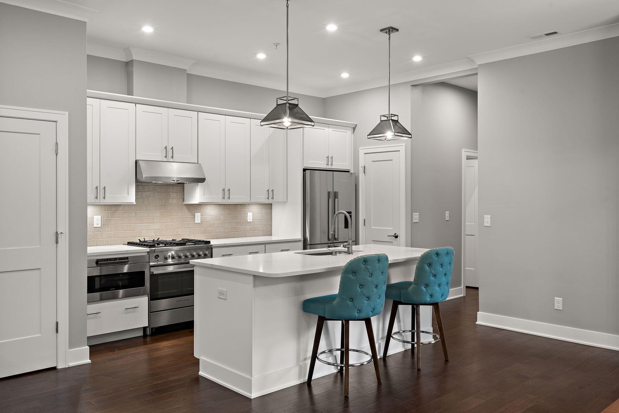 207 Academy Street, Unit 106 Valparaiso, IN 46385 - Photo 8 of 43 a kitchen with kitchen island granite countertop a table chairs refrigerator and microwave