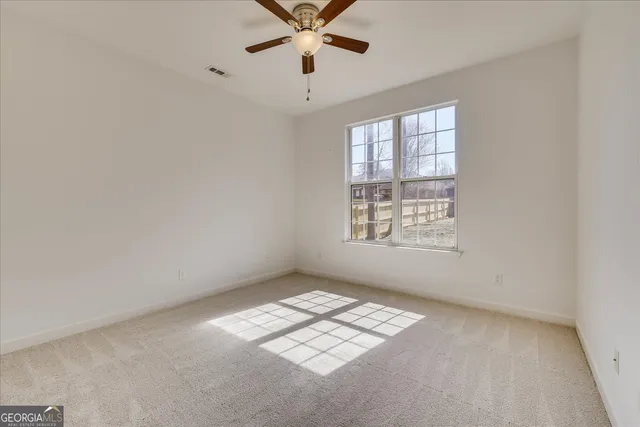 a bathroom with a granite countertop double vanity sink a mirror and a toilet