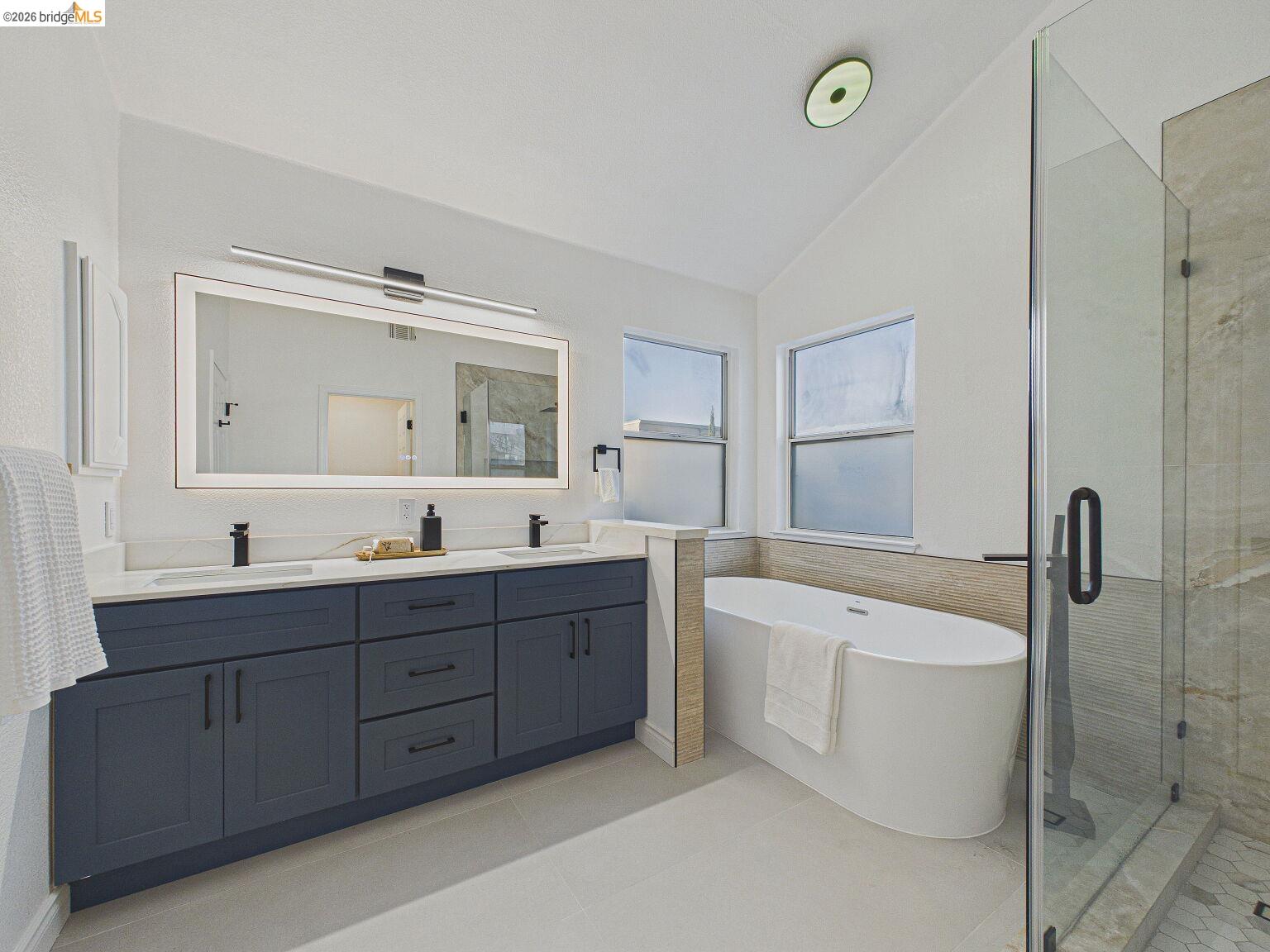 2392 Austin Court Castro Valley, CA 94546 - Photo 41 of 60 Bathroom featuring vaulted ceiling, double vanity, a freestanding bath, and a stall shower