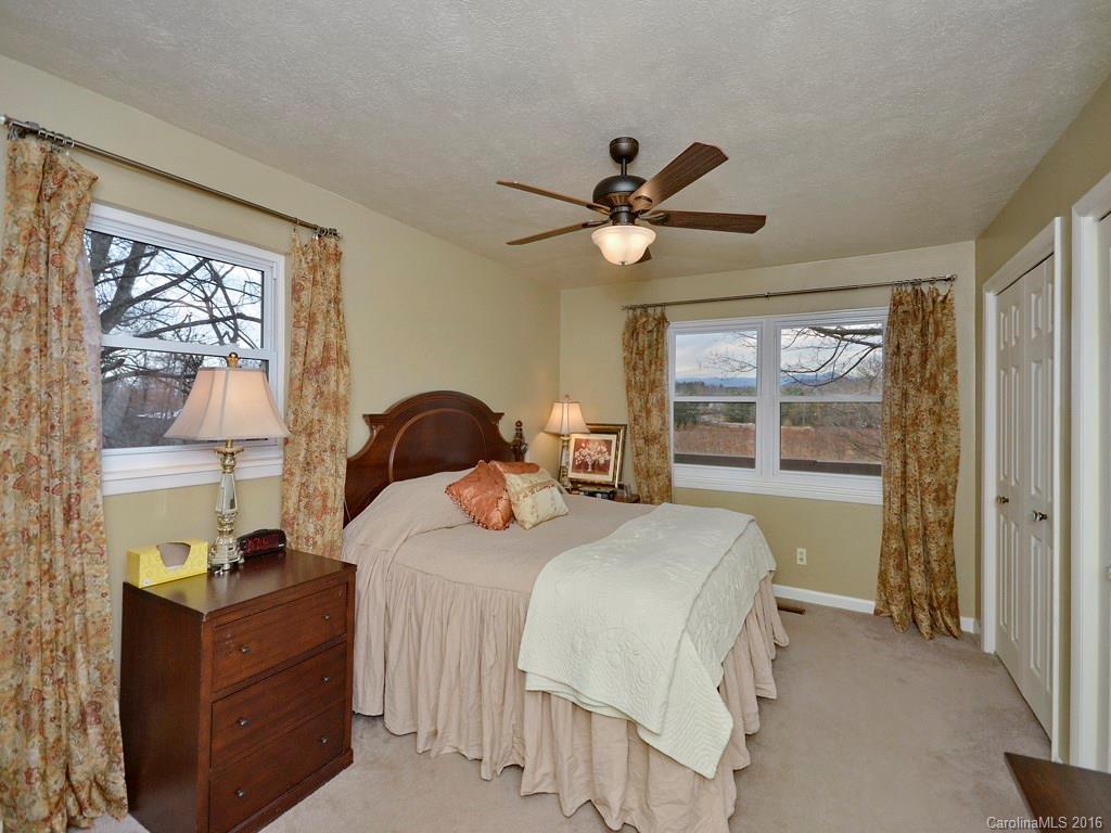 43 Cold Springs Road Hendersonville, NC 28792 - Photo 13 of 24 a bedroom with a bed a window and a chandelier