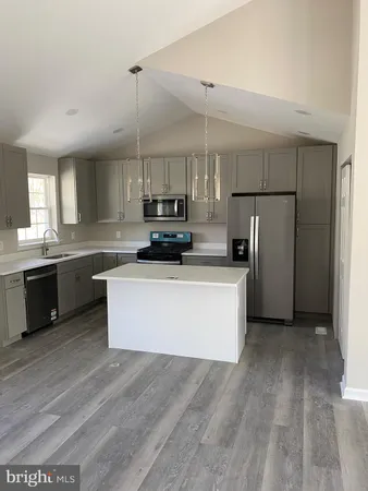a large kitchen with kitchen island a sink stainless steel appliances and cabinets