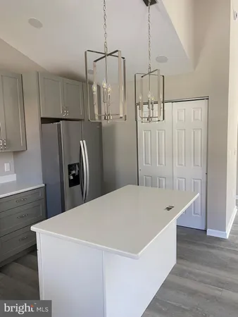 a kitchen with stainless steel appliances a refrigerator and wooden floor