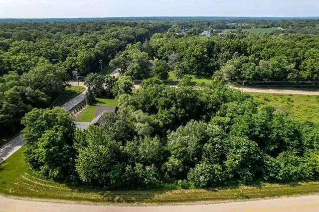 an aerial view of residential house with outdoor space and trees all around
