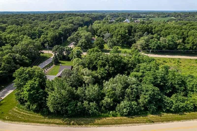 an aerial view of residential house with outdoor space and trees all around