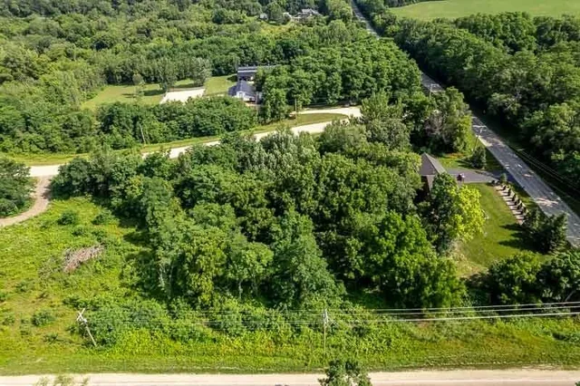 an aerial view of residential house with outdoor space and trees all around