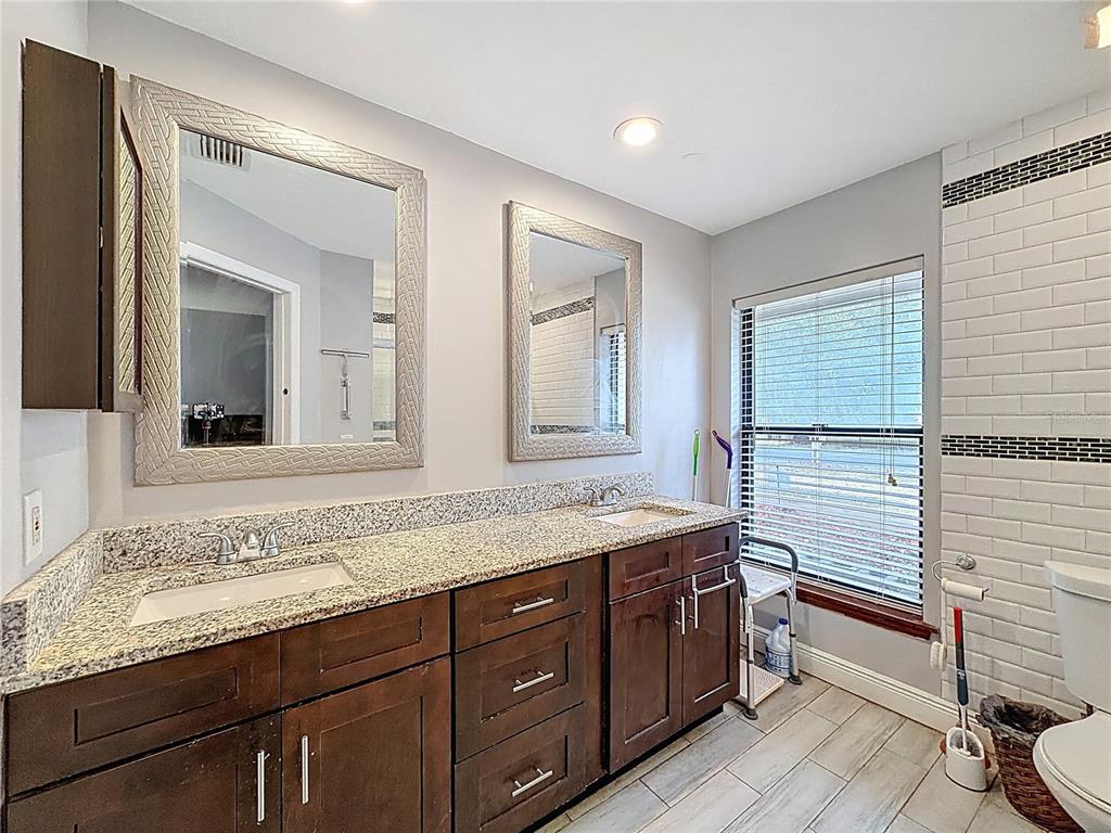 209 1st Street Tavares, FL 32778 - Photo 12 of 21 a bathroom with a granite countertop sink and a mirror