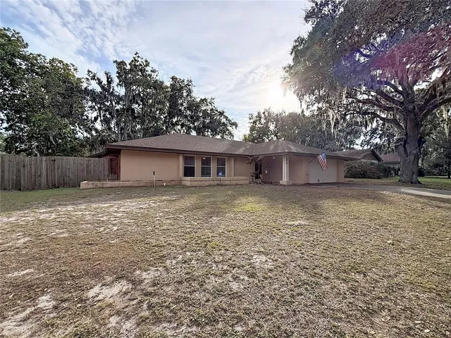 a front view of house with yard and trees in the background