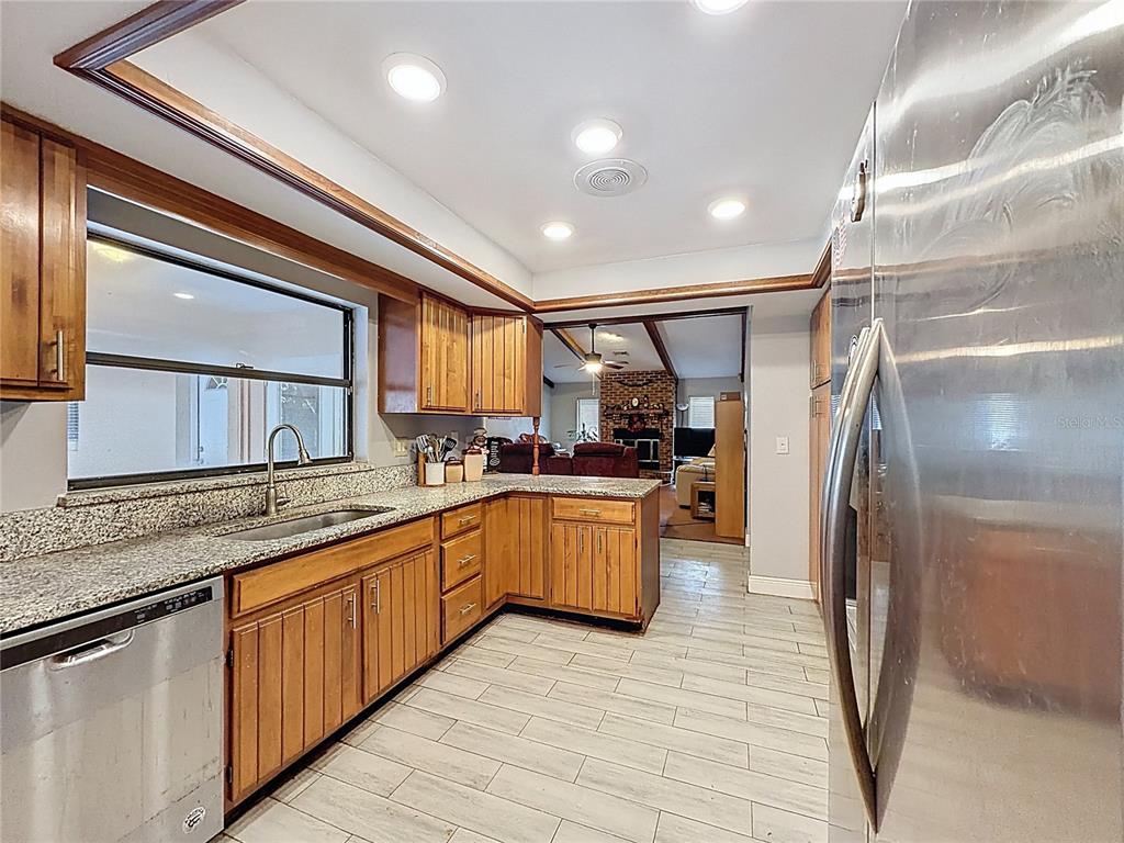 209 1st Street Tavares, FL 32778 - Photo 7 of 19 a large kitchen with stainless steel appliances granite countertop a sink and cabinets