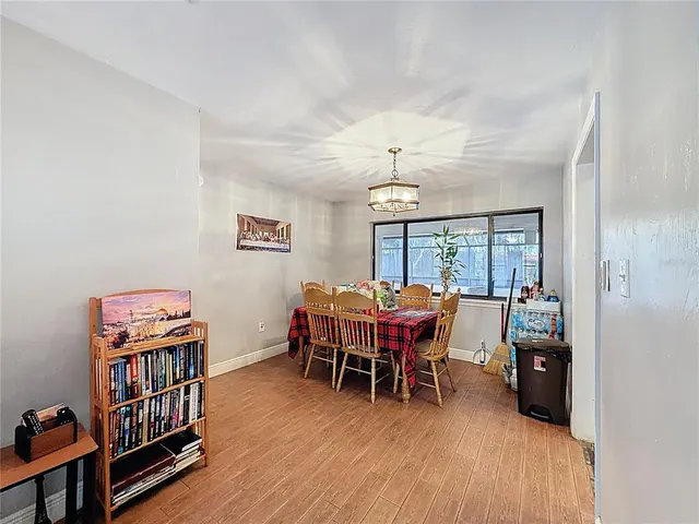 a dining room with furniture a chandelier and wooden floor