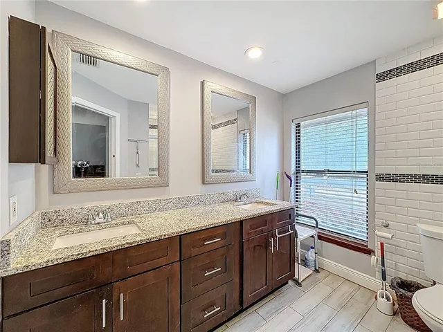 a bathroom with a granite countertop sink and a mirror