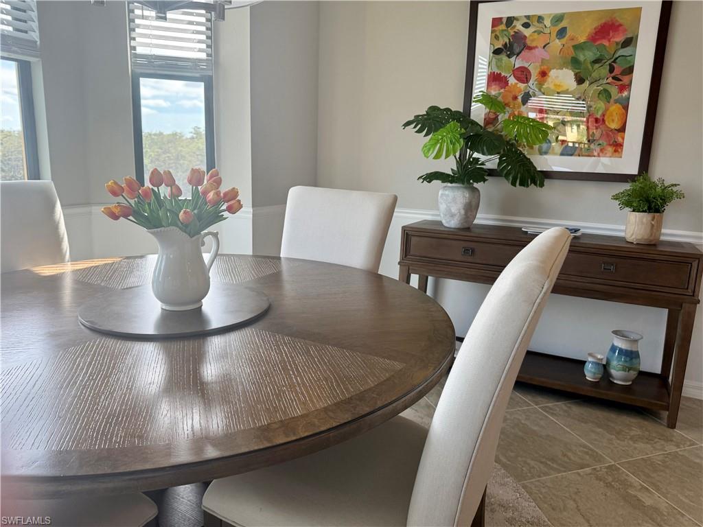 9584 Trevi Court, Unit 5242 Naples, FL 34113 - Photo 14 of 50 a view of a dining room with furniture and a potted plant