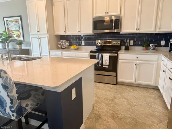 a kitchen with stainless steel appliances a stove a sink and a microwave