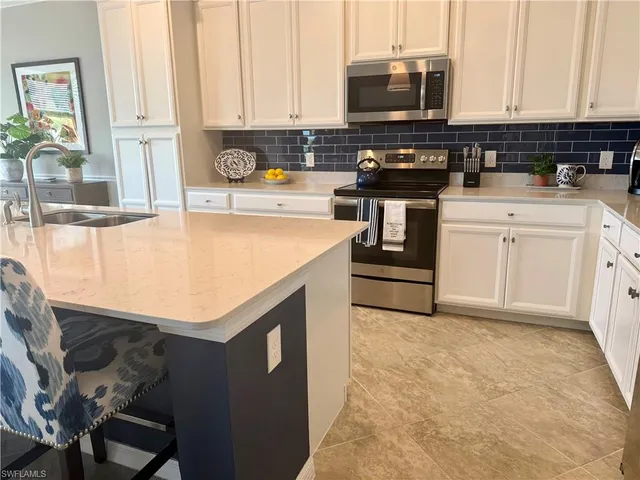 a kitchen with stainless steel appliances a stove a sink and a microwave