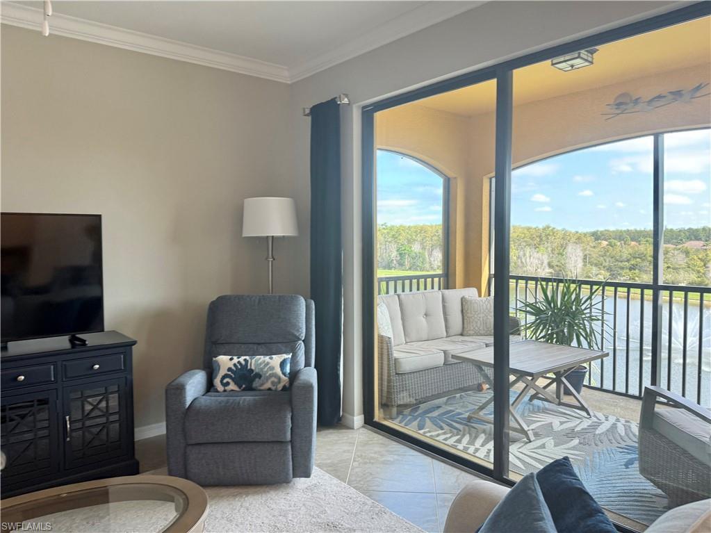 9584 Trevi Court, Unit 5242 Naples, FL 34113 - Photo 21 of 50 a living room with furniture a flat screen tv and a floor to ceiling window
