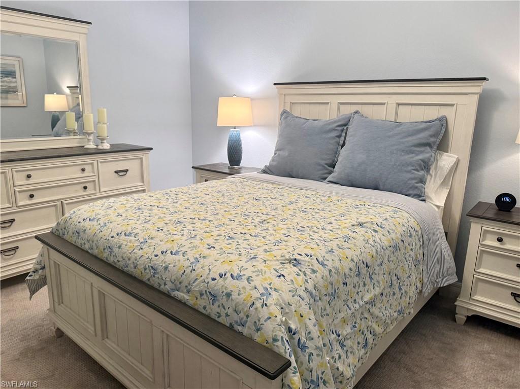 9584 Trevi Court, Unit 5242 Naples, FL 34113 - Photo 28 of 50 a bedroom with a bed and a night stand