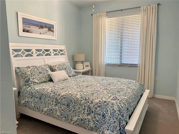 a bedroom with a bed and a window with chair