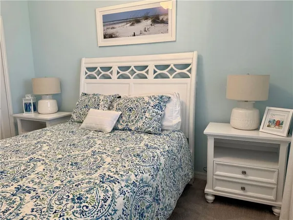 a bedroom with a bed and a lamp on dresser