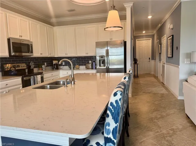 a kitchen with stainless steel appliances granite countertop a refrigerator a stove and a sink with wooden floor