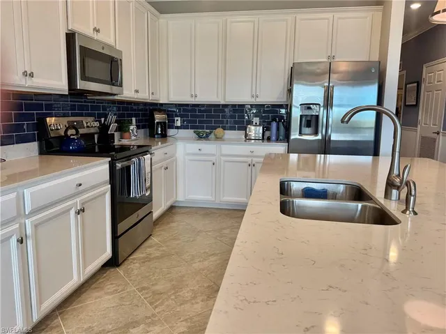 a kitchen with stainless steel appliances granite countertop a sink a stove and a microwave