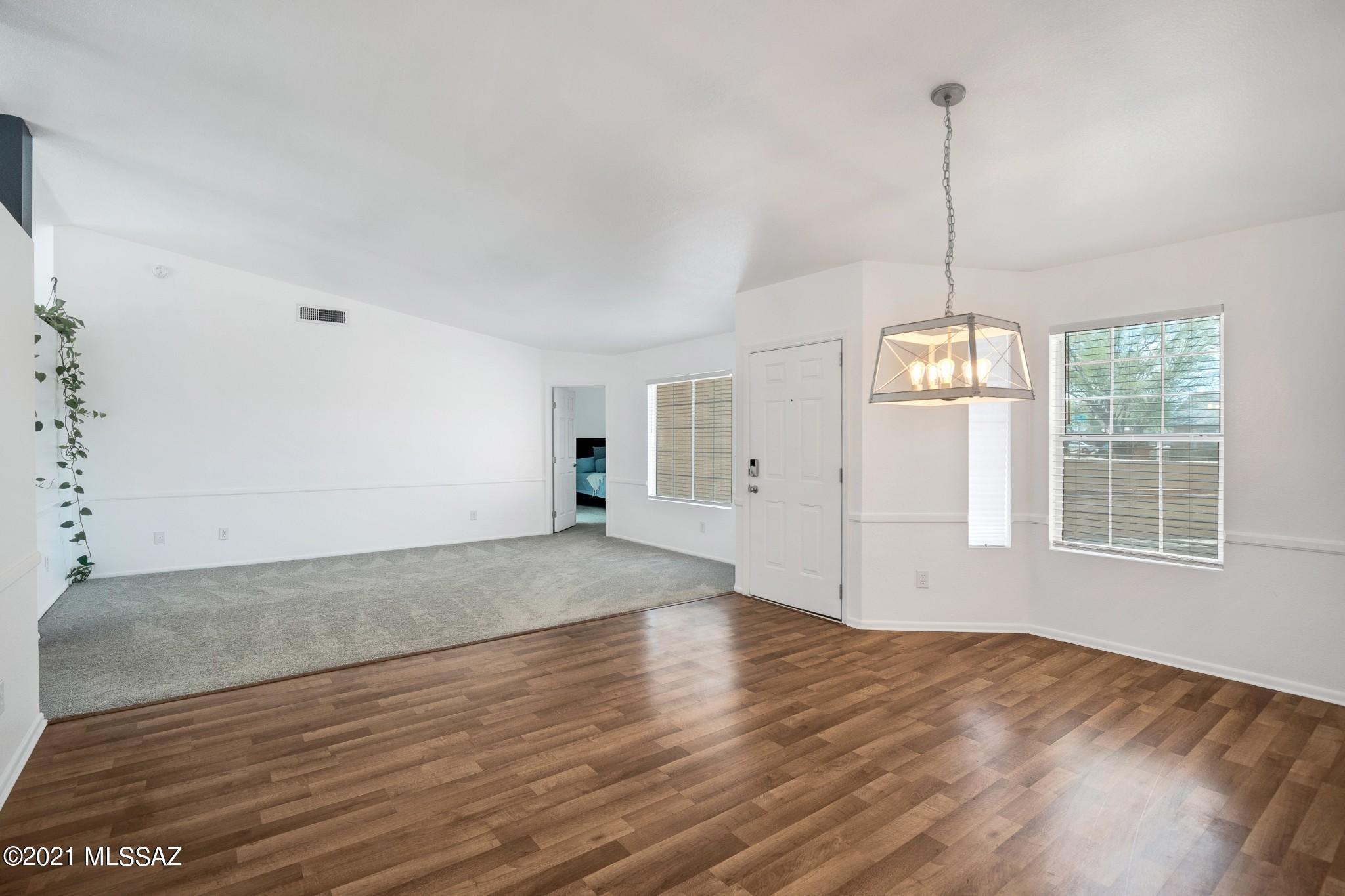 9671 East Azuma Way Tucson, AZ 85747 - Photo 3 of 31 a view of an empty room with wooden floor and a window