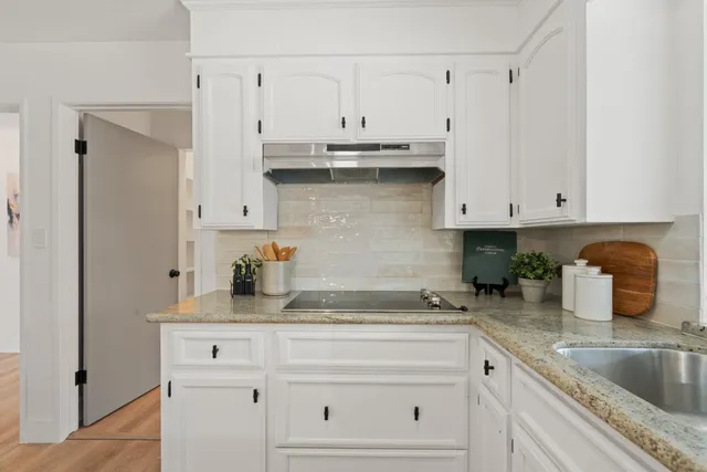 a kitchen with white cabinets and white appliances