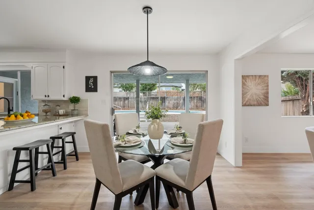 a dining room with furniture a chandelier and wooden floor