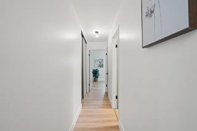 a view of a hallway with wooden floor