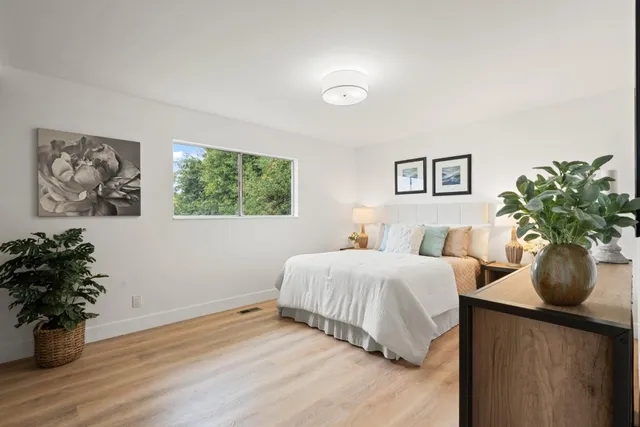 a bedroom with a bed and a potted plant