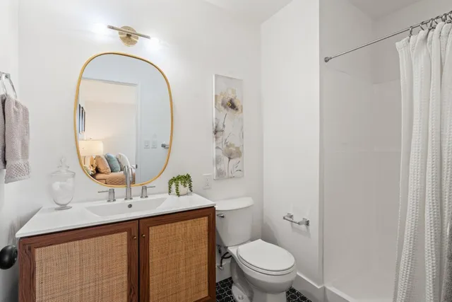 a bathroom with a sink a mirror a toilet and a window