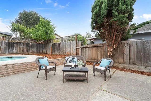 a view of patio with table and chairs with wooden fence and floor