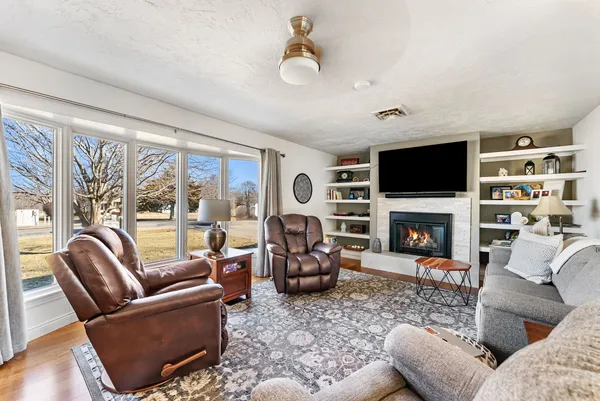 a living room with furniture a flat screen tv and a fireplace
