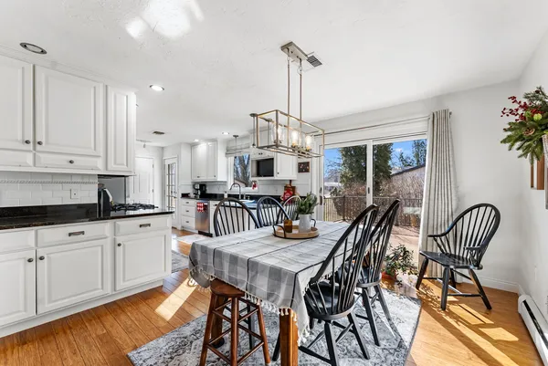 a kitchen with a table chairs and white cabinets