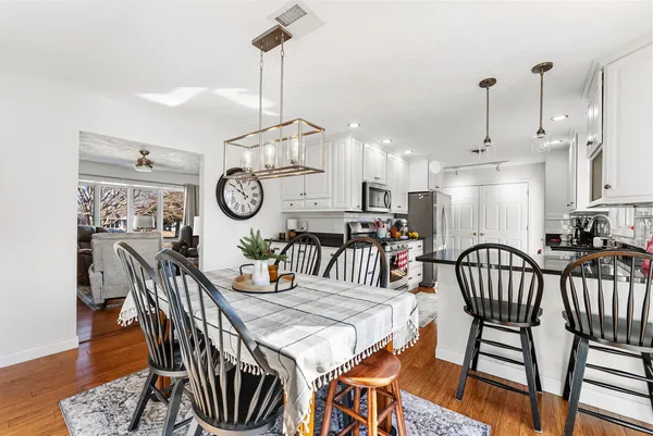 a view of a dining room and livingroom with furniture wooden floor a chandelier