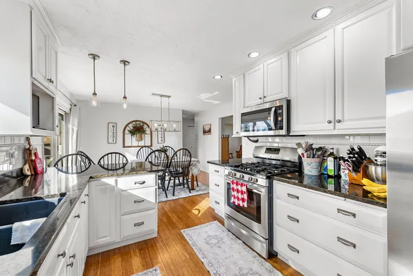 a kitchen with stainless steel appliances kitchen island granite countertop a stove and a sink