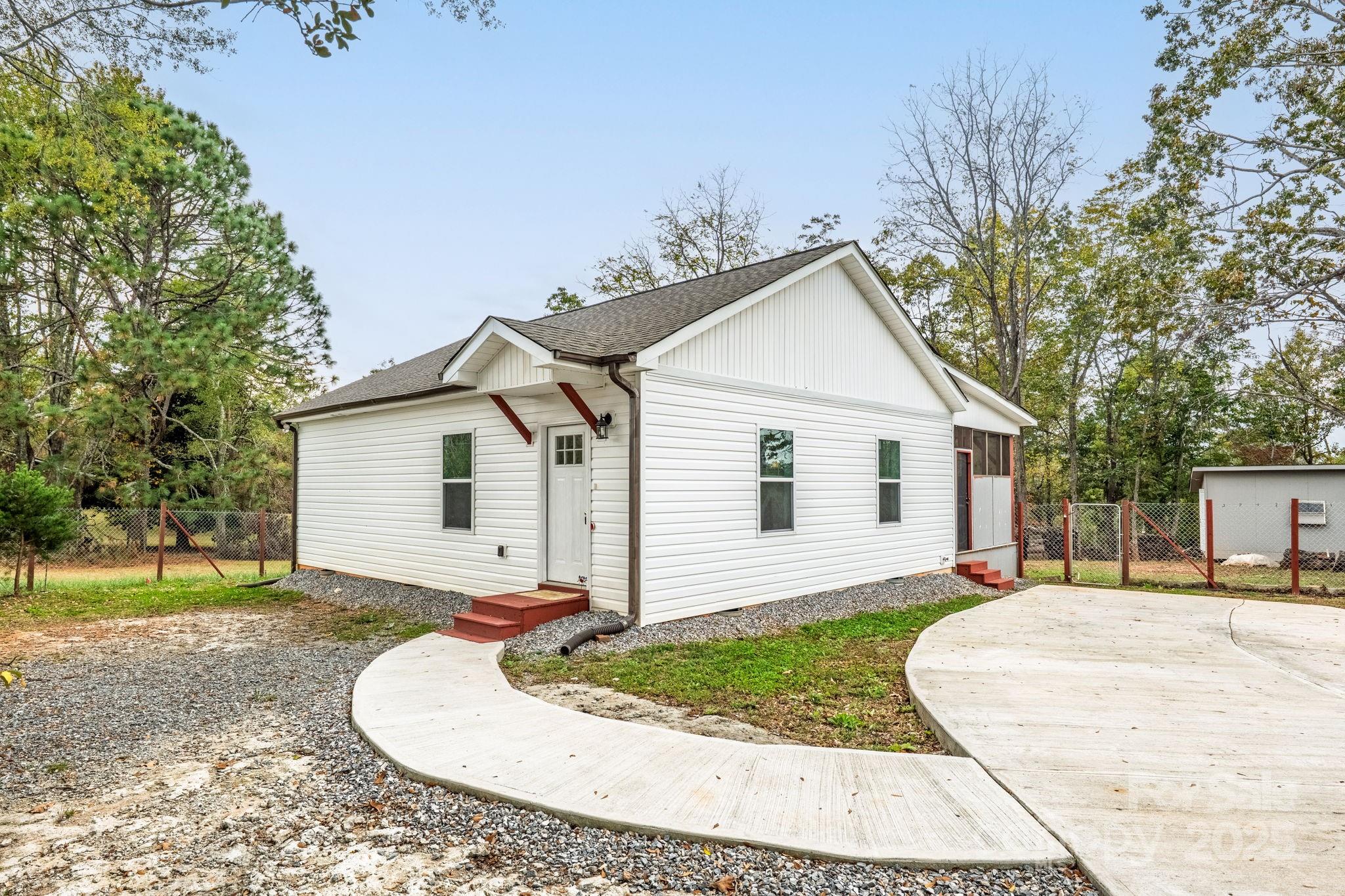 845 Spindale Street Spindale, NC 28160 - Photo 2 of 30 a view of a white house with a small yard and palm trees
