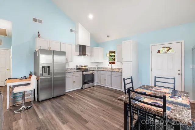 a kitchen with a refrigerator a sink and chairs