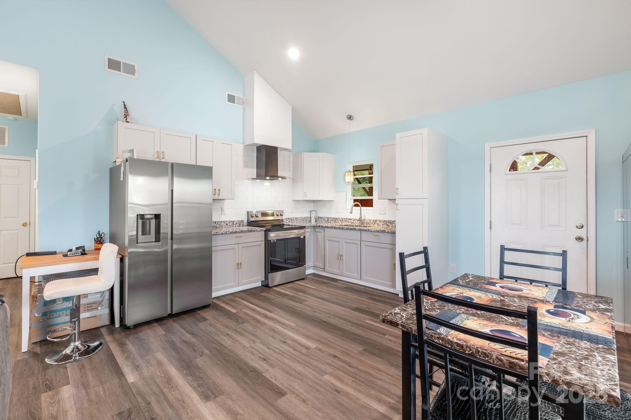 845 Spindale Street Spindale, NC 28160 - Photo 7 of 30 a kitchen with a refrigerator a sink and chairs