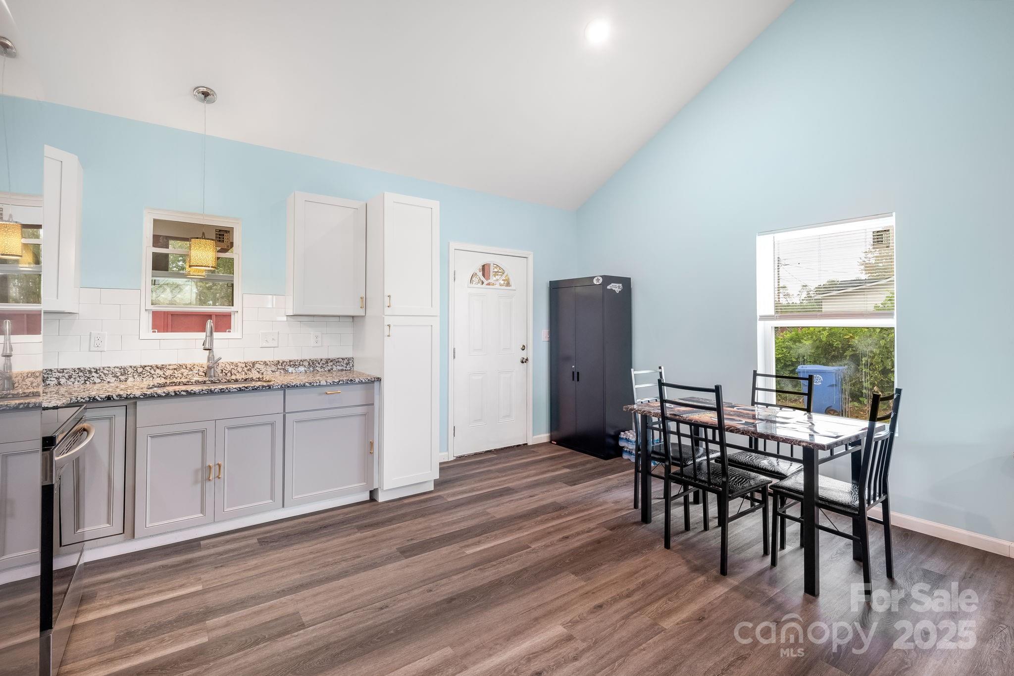 845 Spindale Street Spindale, NC 28160 - Photo 8 of 30 a open kitchen with granite countertop a dining table chairs and white stainless steel appliances