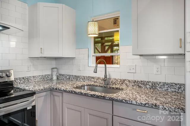 a kitchen with stainless steel appliances granite countertop a sink and a white cabinets