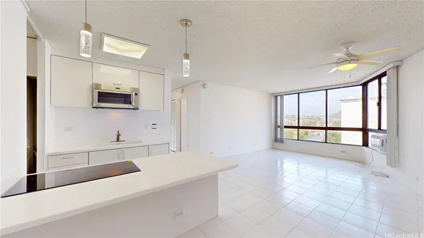 a large white kitchen with a large window a sink and a counter top space