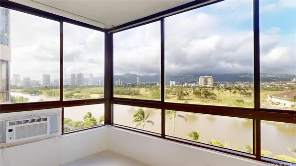 a view of an empty room with a large window with kitchen view