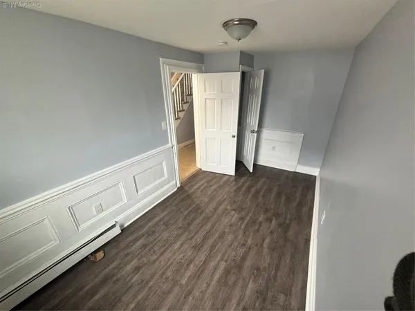 a view of an empty room with wooden floor