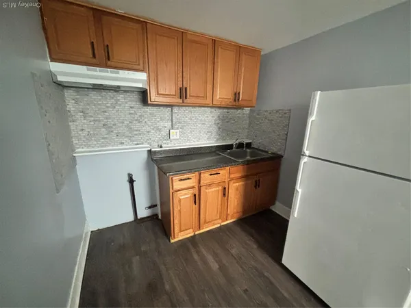a kitchen with a refrigerator sink and cabinets