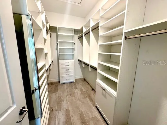 a view of walk in closet with empty racks