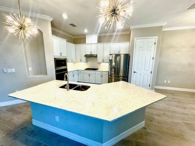 a kitchen with kitchen island a stove a sink and a refrigerator