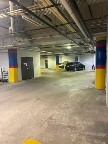 a kitchen with stainless steel appliances granite countertop a stove top oven a sink a refrigerator and a dining table with wooden floor