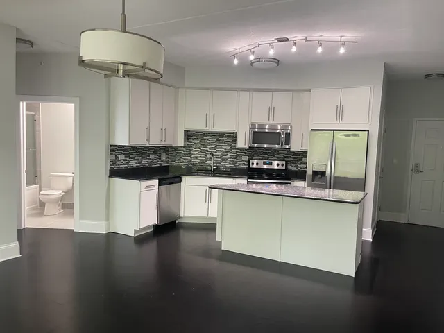 a bathroom with a granite countertop toilet and a sink